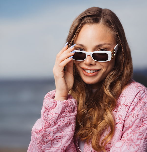 Jeune femme portant des lunettes de soleil rectangulaires blanches
